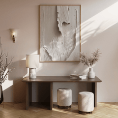 Modern entryway hallway interior with a brown wooden console table, beige and white abstract artwork framed, and decorative items.