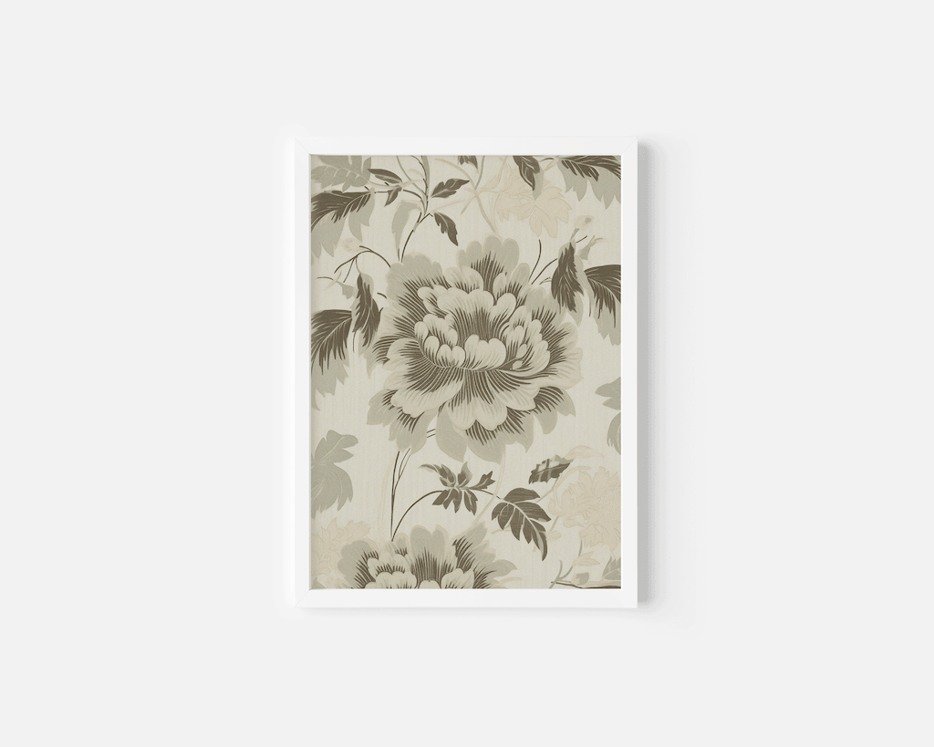 Close-up of an elegant green floral wall art print with white frame and beige background on a white wall.