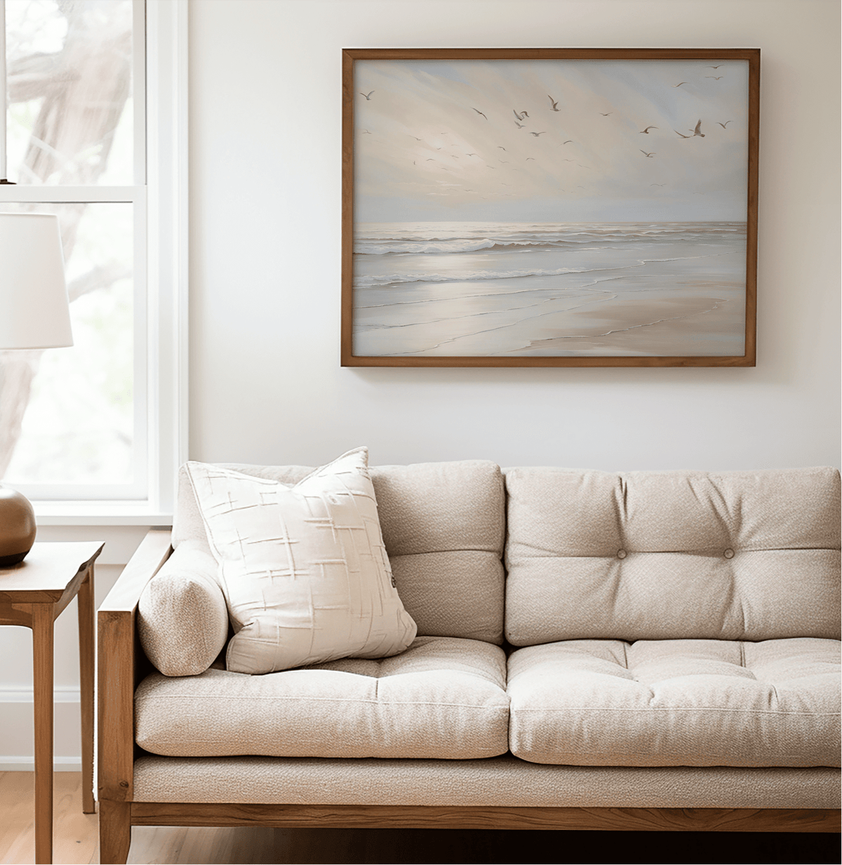 Coastal beach print framed in natural wood featuring seagulls over soft ocean waves in a neutral, minimalist living room — calming artwork for minimalist interior styling