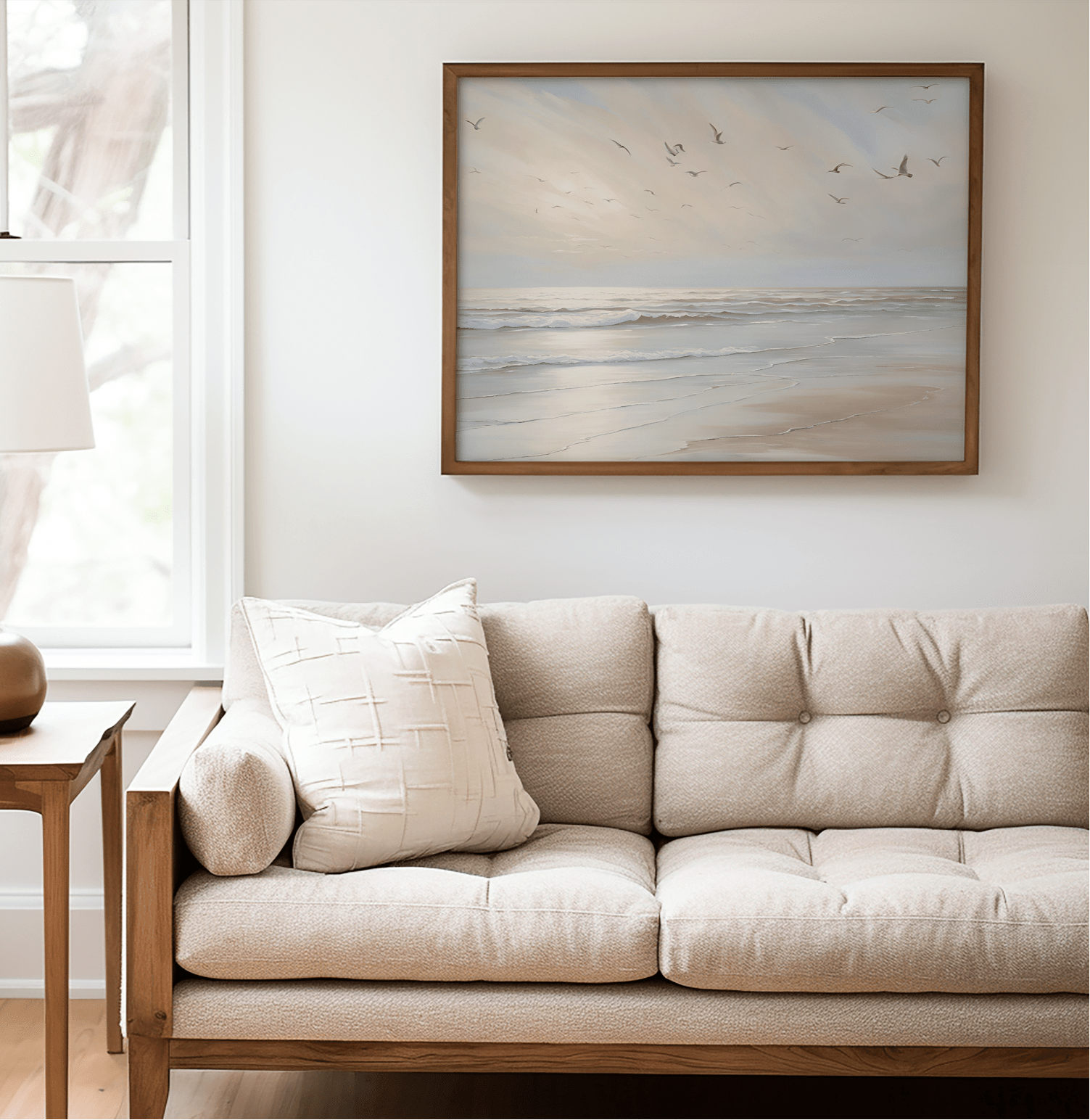 Coastal beach print framed in natural wood featuring seagulls over soft ocean waves in a neutral, minimalist living room — calming artwork for minimalist interior styling