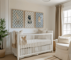 Giraffe, bear and frog nursery prints framed above a white crib in a modern nursery