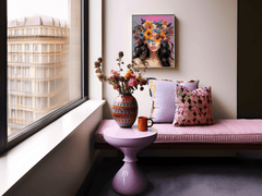 Framed vibrant flower crown canvas wall art print featuring modern feminine portrait of a woman and vivid blossoms on her head in a pink and purple dining area and a contemporary vase with flowers.