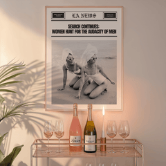 Funny newspaper print in a natural frame above a glass bar cart with wine bottles and a candle