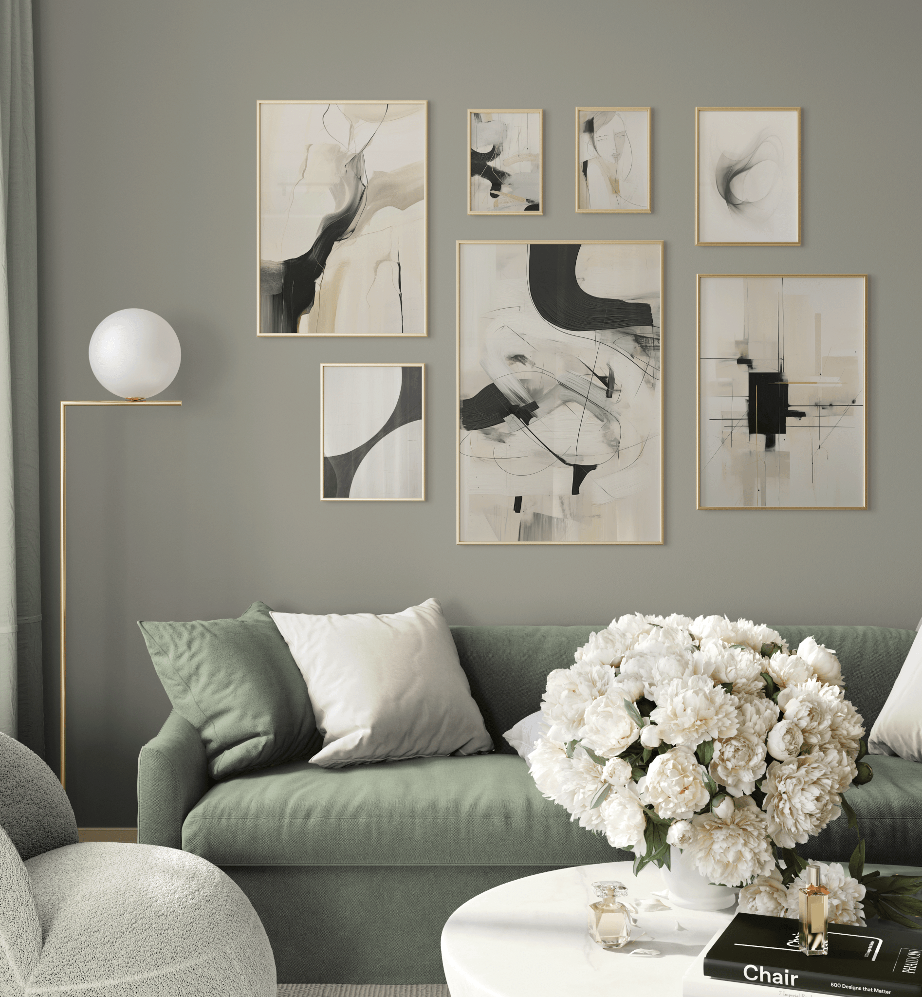 Curated gallery wall of neutral black and white abstract prints hung over an olive-green sofa in a modern living room.