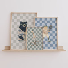 Giraffe bear and frog animal nursery wall art trio in neutral beige and green tones, framed canvas set for woodland baby nursery framed on a wooden shelf