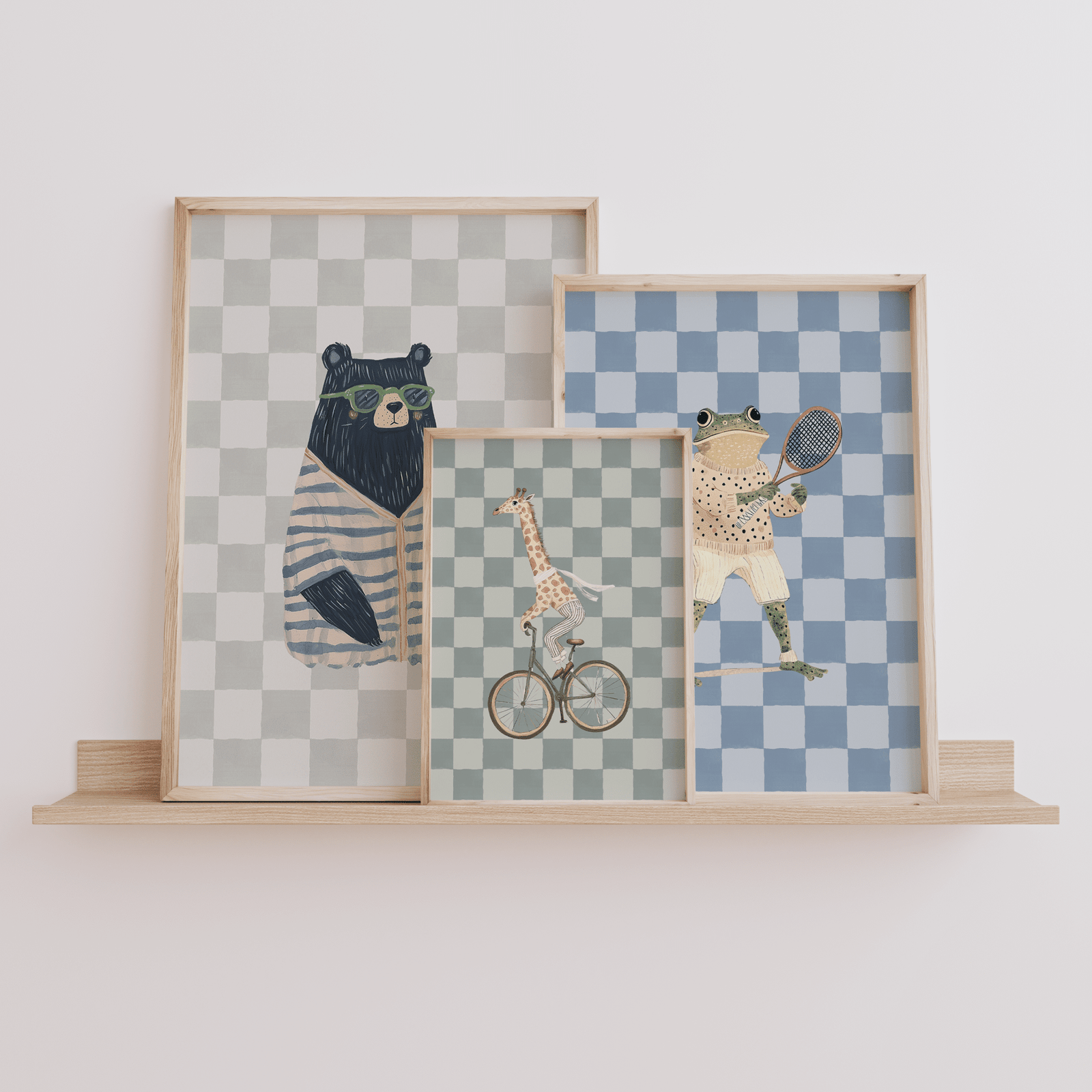 Giraffe bear and frog animal nursery wall art trio in neutral beige and green tones, framed canvas set for woodland baby nursery framed on a wooden shelf