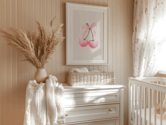 Girl nursery wall art with framed pink cherry bow print on beige panelled wall