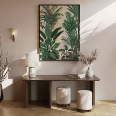 Green tropical leaf wall art in a wood frame above a console table in a sunlit entryway