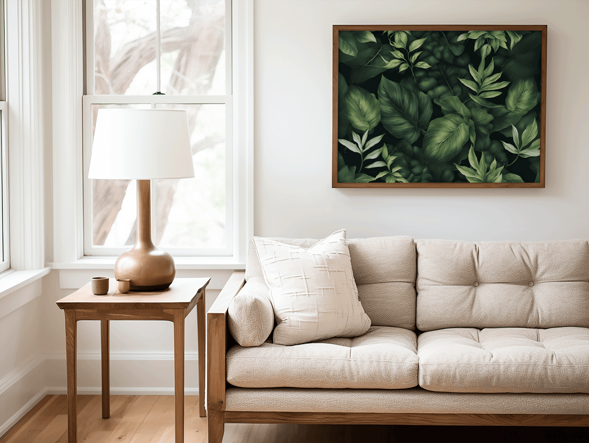 Green tropical leaf print in a natural frame above a beige tufted sofa with a table lamp