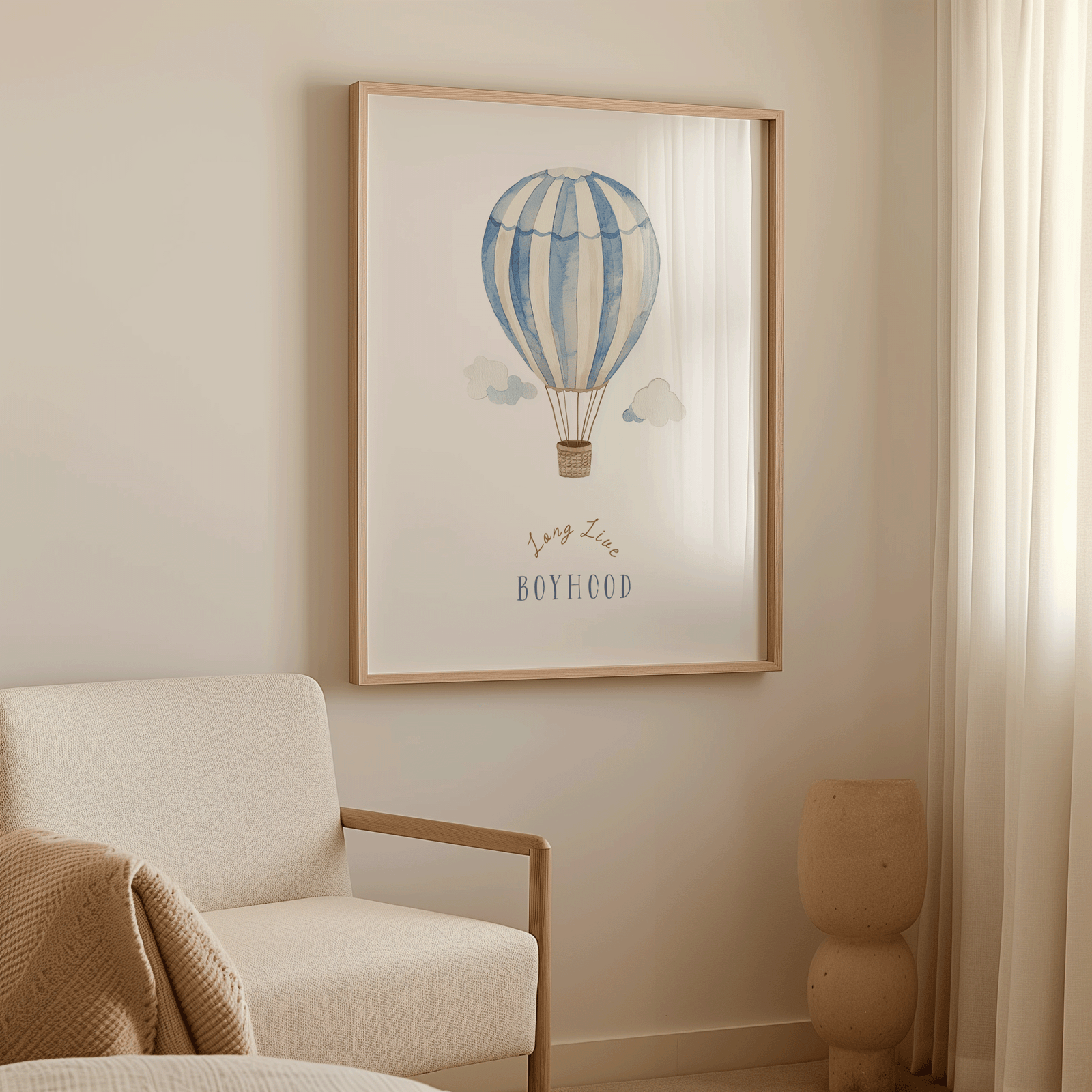 Blue hot air balloon boy nursery wall art in an oak frame above a cream armchair