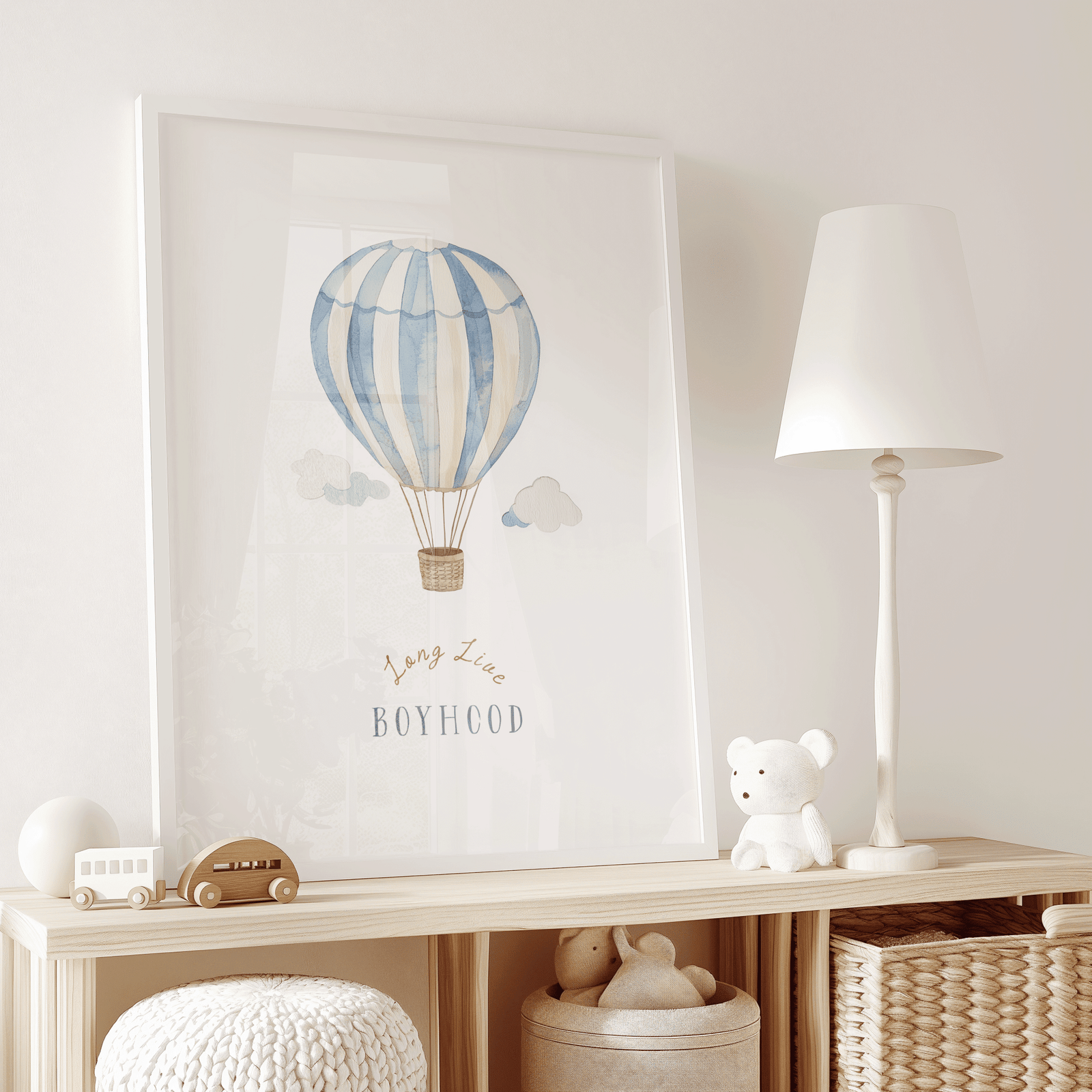 Hot air balloon boy nursery wall art in a white frame on a dresser with wooden toys