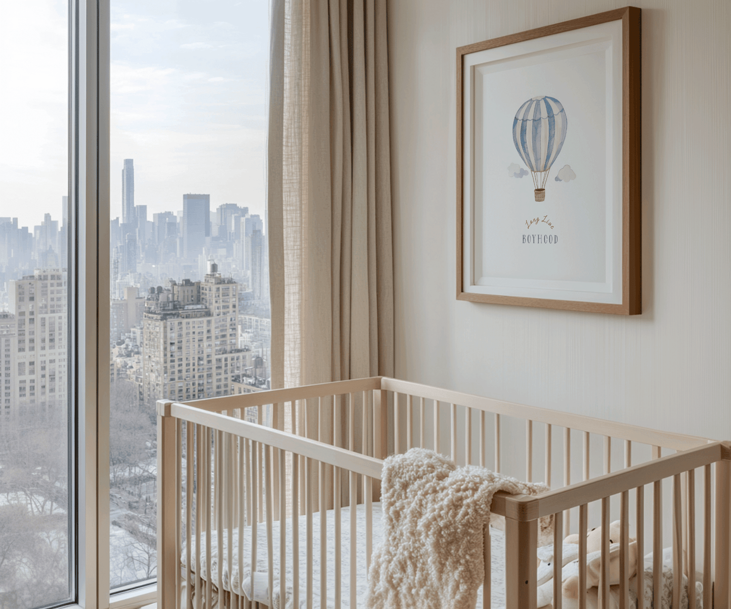 Hot air balloon nursery print in an oak frame above a crib in a bright boy's nursery