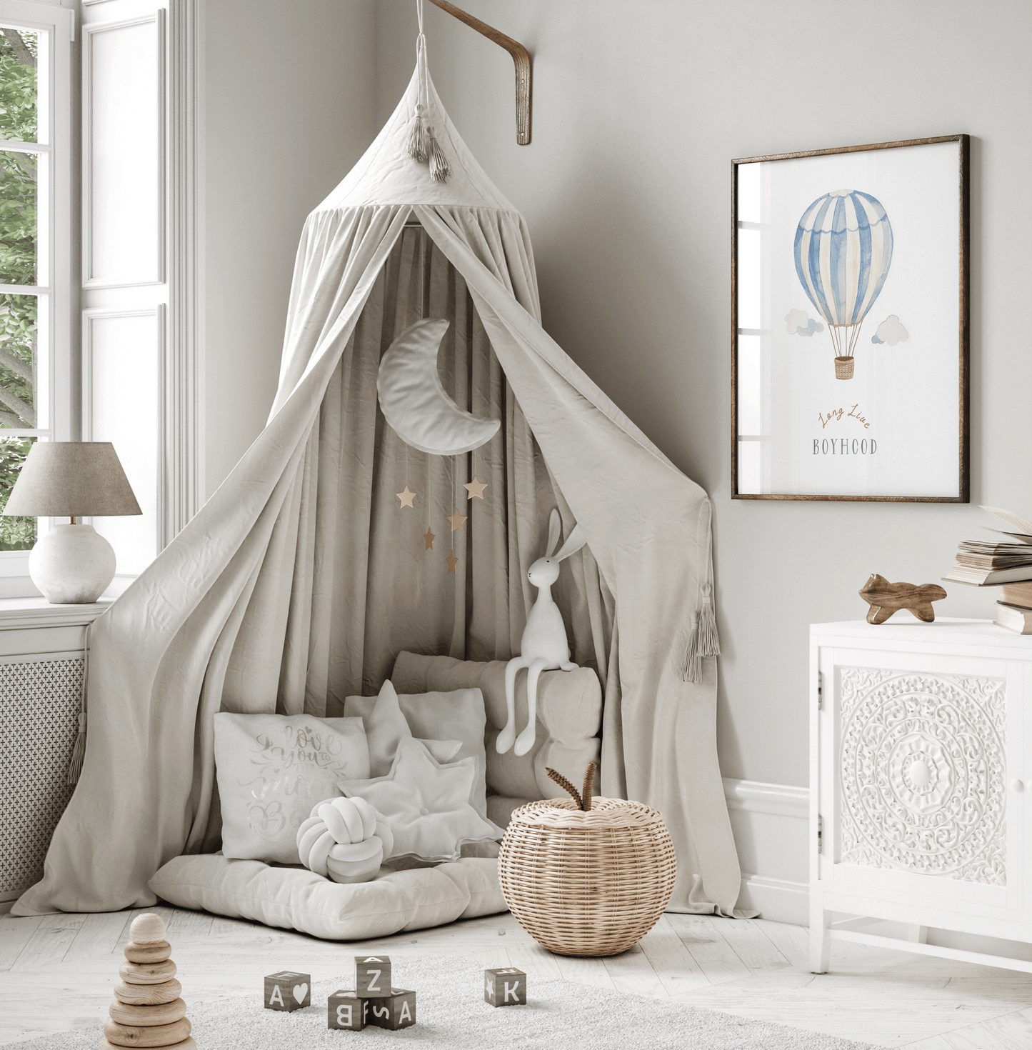 Hot air balloon nursery print in a wood frame beside a canopy play nook in a kids' room