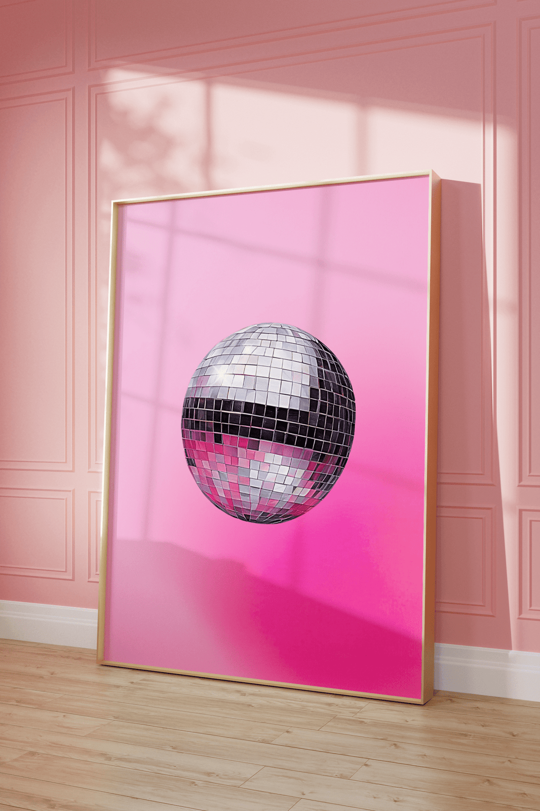 Hot pink disco ball print in a natural frame leaning against a pink panelled wall
