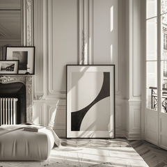 Oversized black and white curve abstract in a black frame leaning against a Parisian fireplace in a modern living room.