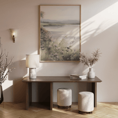 Large neutral landscape wall art above a wooden console table in an entryway