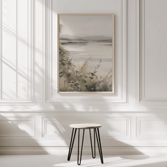 oversized soft lake landscape wall art framed on a white minimal wall with wainscotting and stool