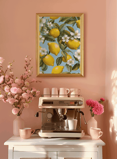 Lemon framed art print with gold frame on a pink wall above a home coffee bar with flowers and espresso cups
