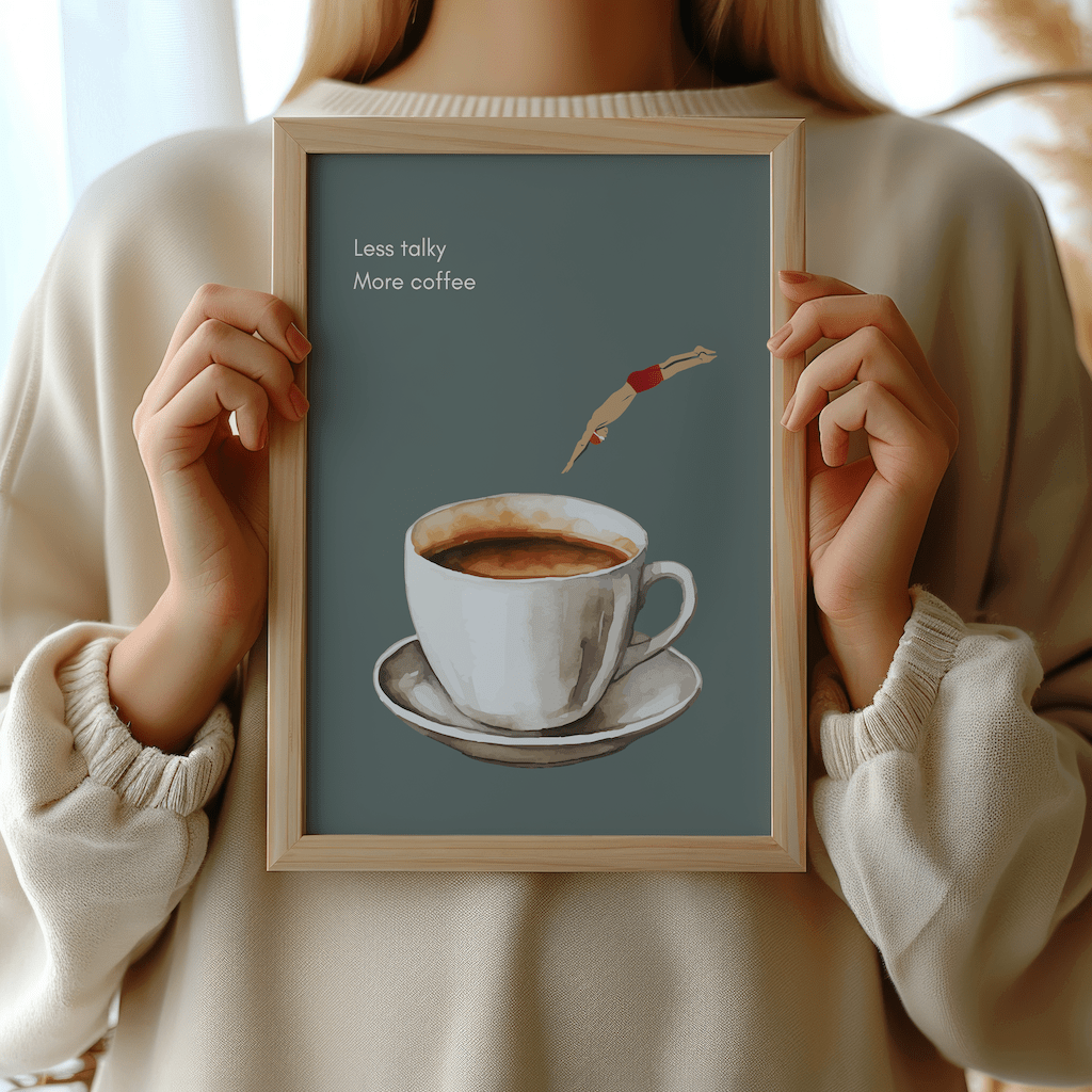 Woman in a cream sweater holding a framed less talky, more coffee print