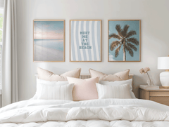 Set of three framed prints above a bed: a beach scene, a palm tree and "meet me at the beach"