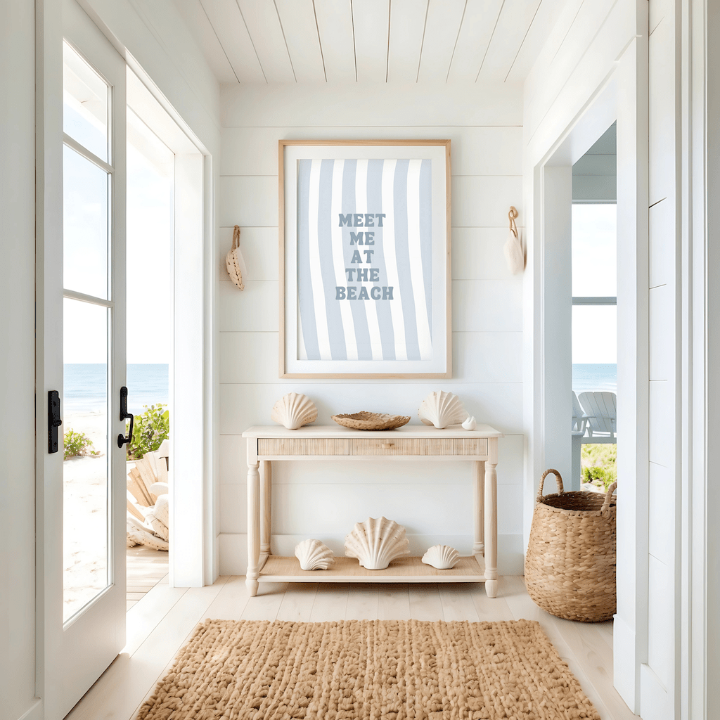 Natural framed meet me at the beach wall art above a console table in a coastal entryway