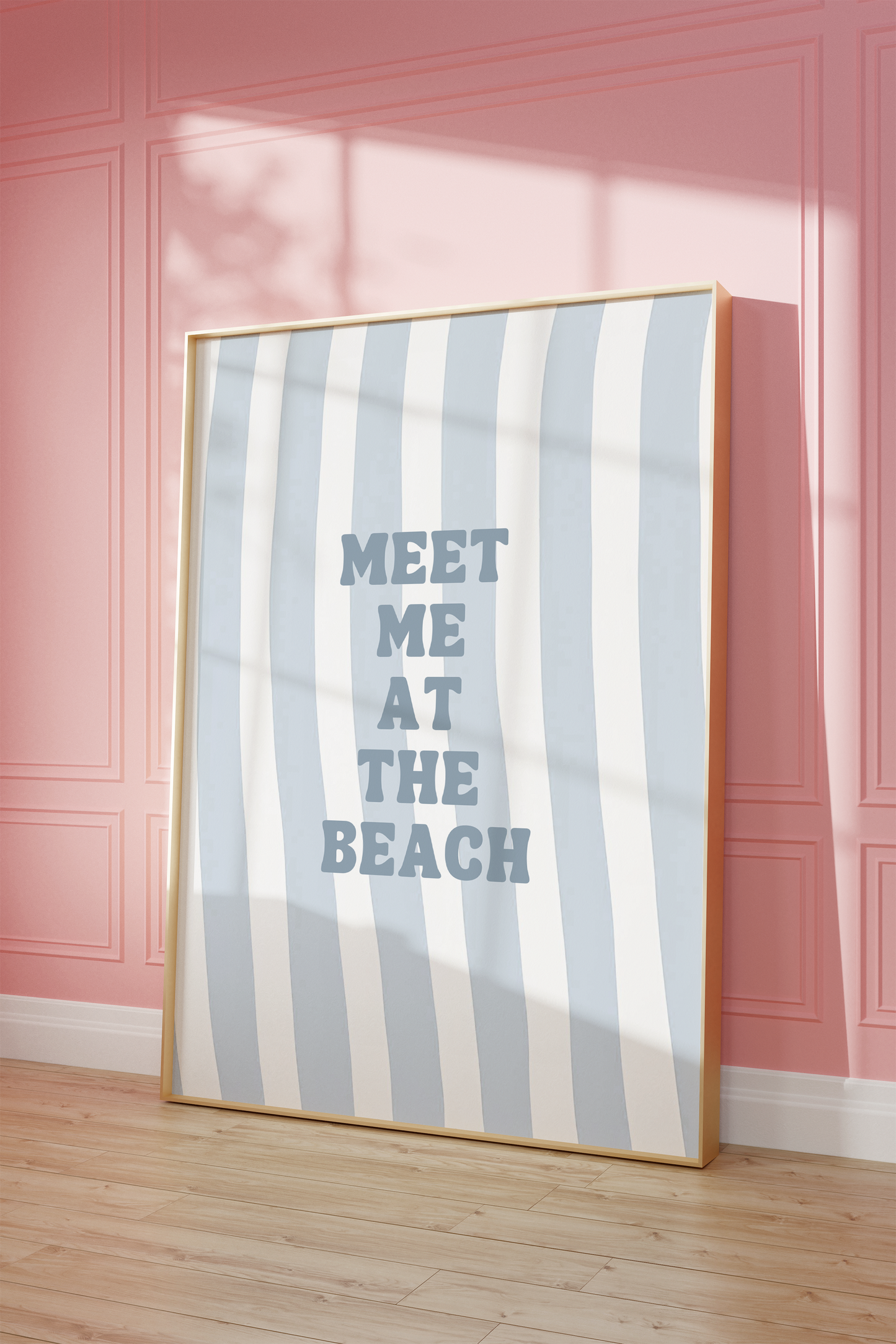 Natural framed meet me at the beach wall art leaning against a pink wall