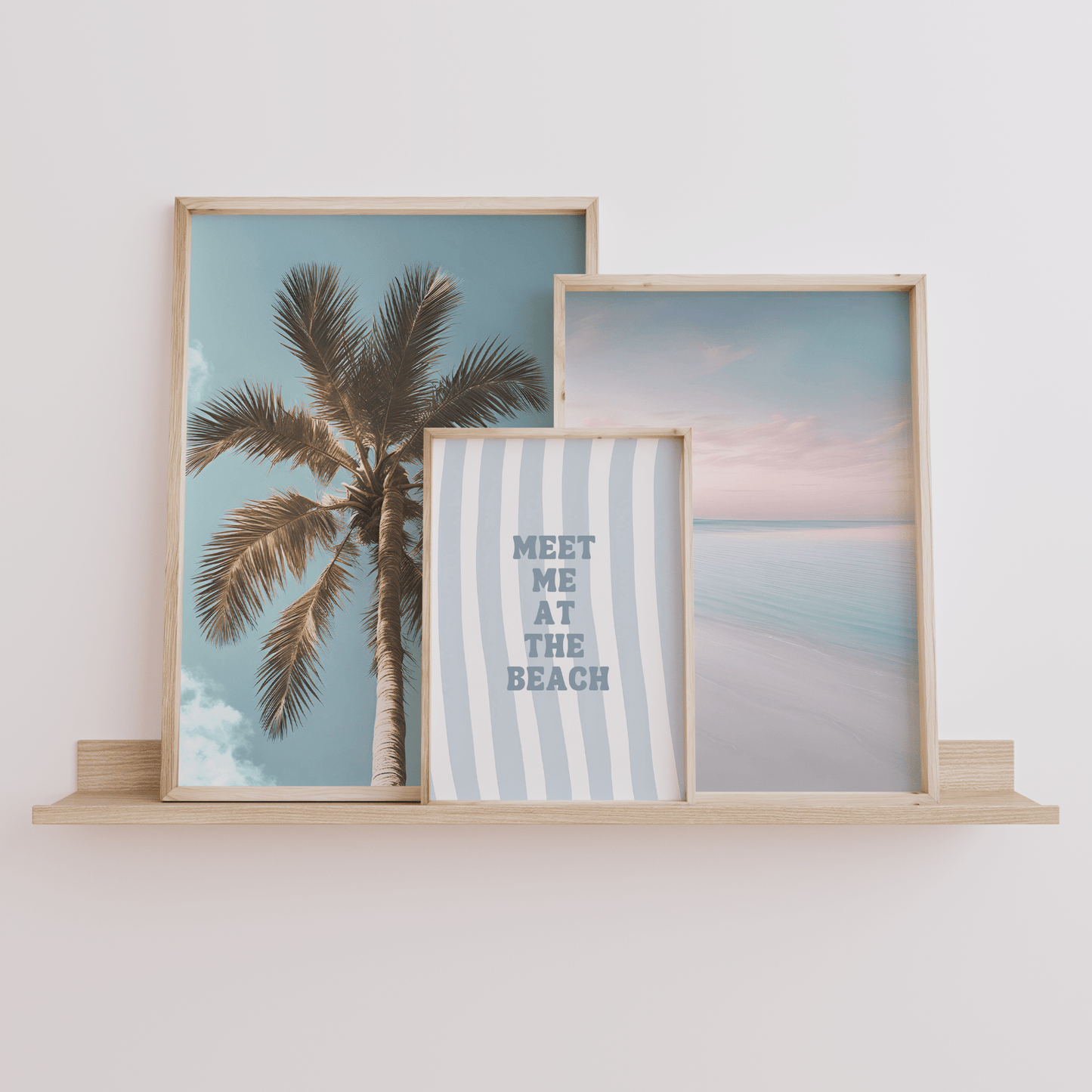 Meet me at the beach wall art in natural frame styled on a shelf with palm tree and beach prints set of 3