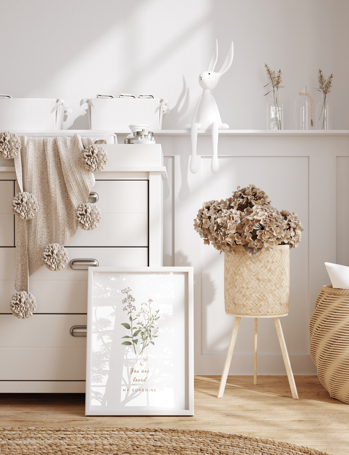 Minimal nursery wall art with a delicate floral illustration in a white frame, styled with light wood furniture