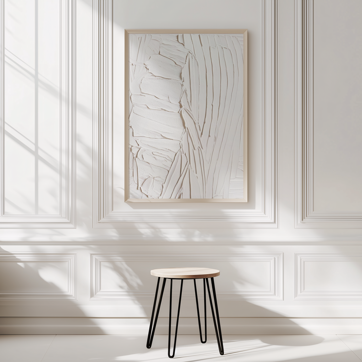 White faux textured abstract wall art in natural wood frame on bright white wall with a small stool