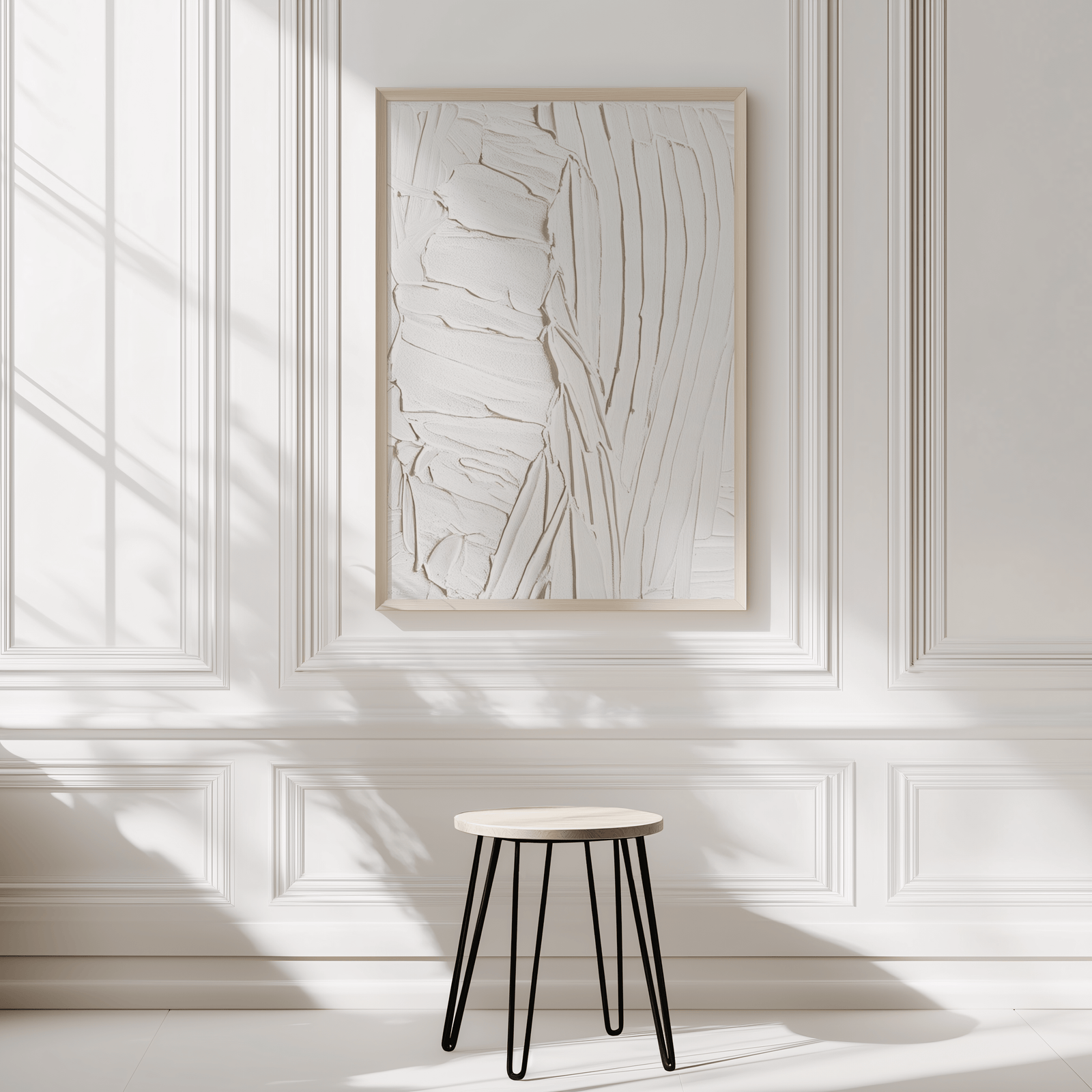 White faux textured abstract wall art in natural wood frame on bright white wall with a small stool