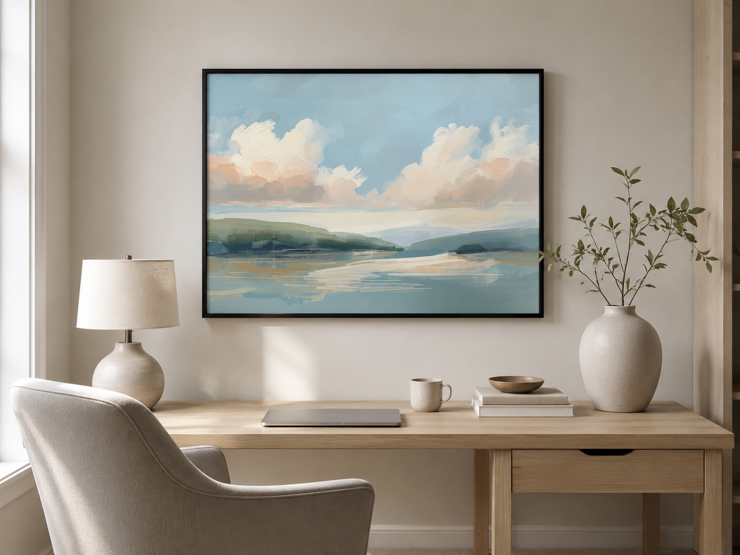 Framed pastel landscape wall art in a modern home office above a light wood desk with a slim black frame, neutral decor and soft daylight.