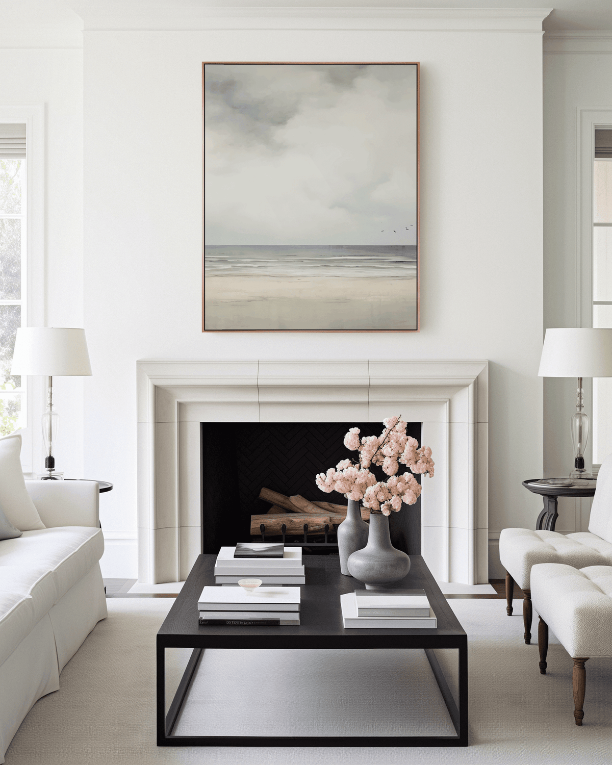 Modern living room with a fireplace, coffee table, and vintage muted beach coastal landscape framed above fireplace.