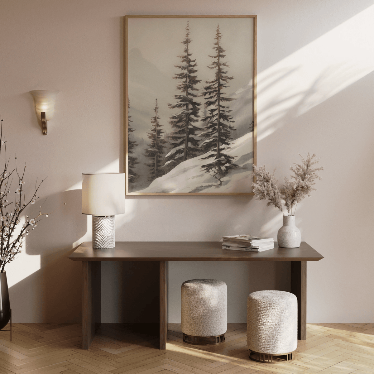 Large winter forest wall art with snow-covered pines styled above minimal wooden entryway table and vases