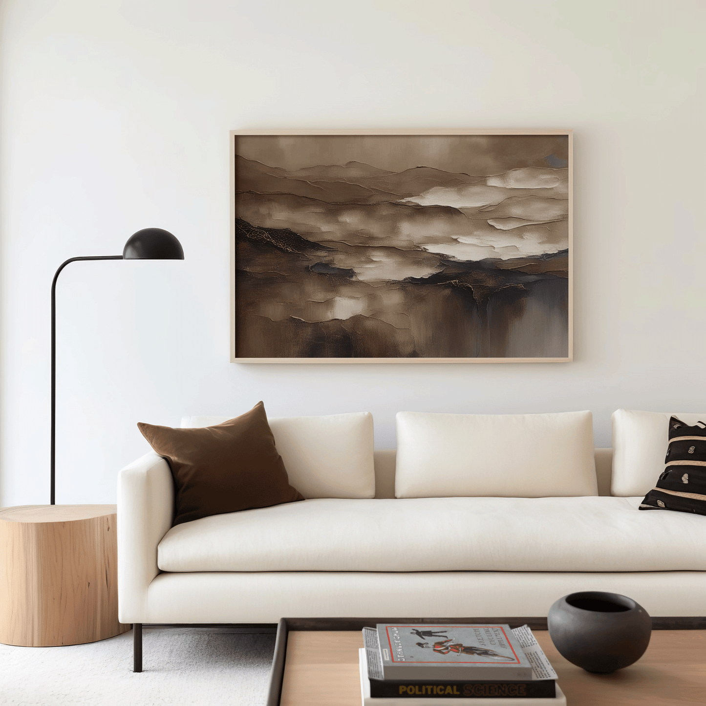 Moody brown abstract wall art in a natural wood frame above a cream sofa in a modern living room