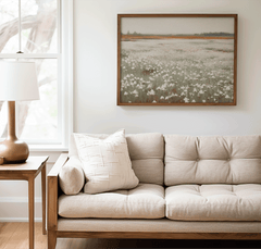 Muted wildflower field print framed above a beige couch in a neutral living room
