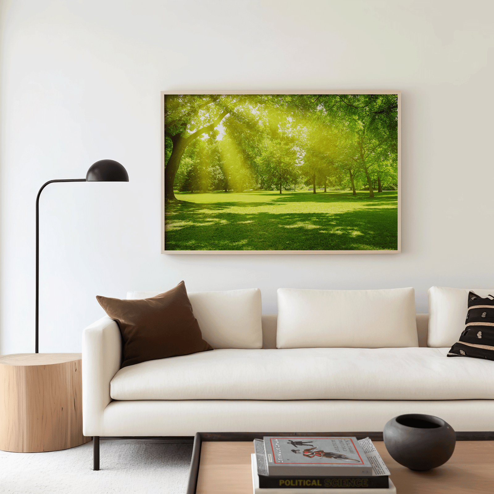 Oversized forest landscape wall art featuring sunlight through trees, displayed in modern neutral living room with crisp white sofa and wood furniture, serene nature home decor