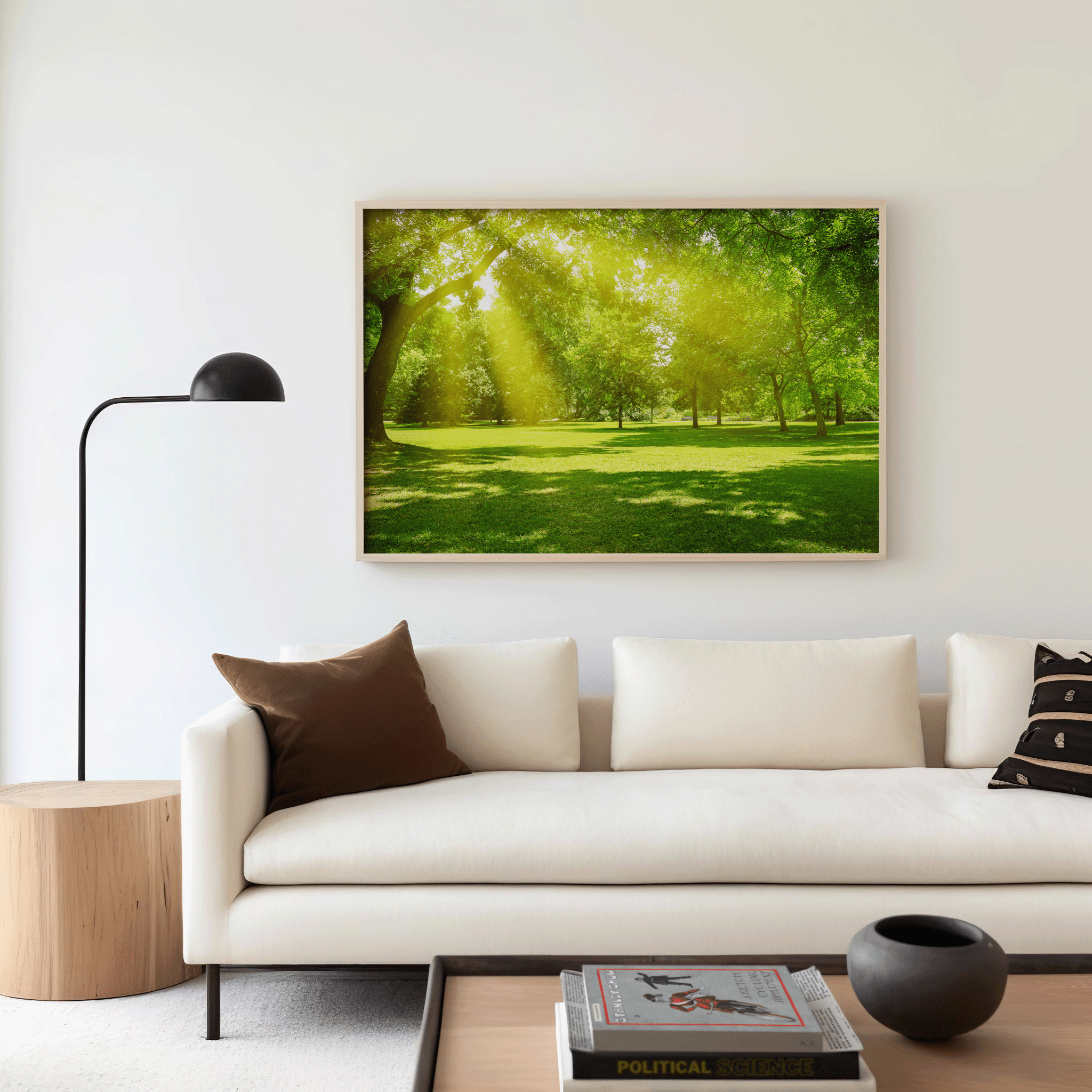 Oversized forest landscape wall art featuring sunlight through trees, displayed in modern neutral living room with crisp white sofa and wood furniture, serene nature home decor