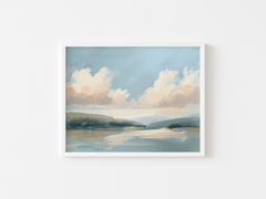 Nature coastal landscape wall art with a white frame, clouds and water on a white wall