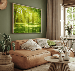 Large forest print with sunlight streaming through green trees above a tan sectional sofa in a warm boho living room