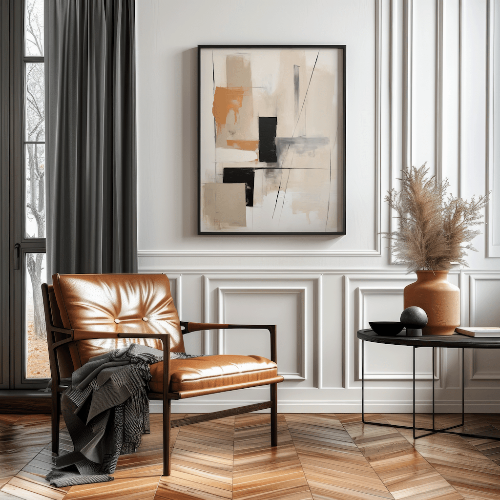 Minimalist tan and black geometric canvas print in a black frame styled over a leather accent chair in a classic paneled corner.