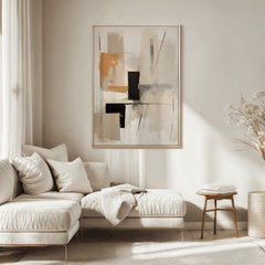 Large tan and black geometric abstract wall art framed and hung above a light cream sectional in a sunlit modern living room.