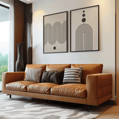 Neutral abstract wall art set in black frames above a cognac leather sofa in a modern living room