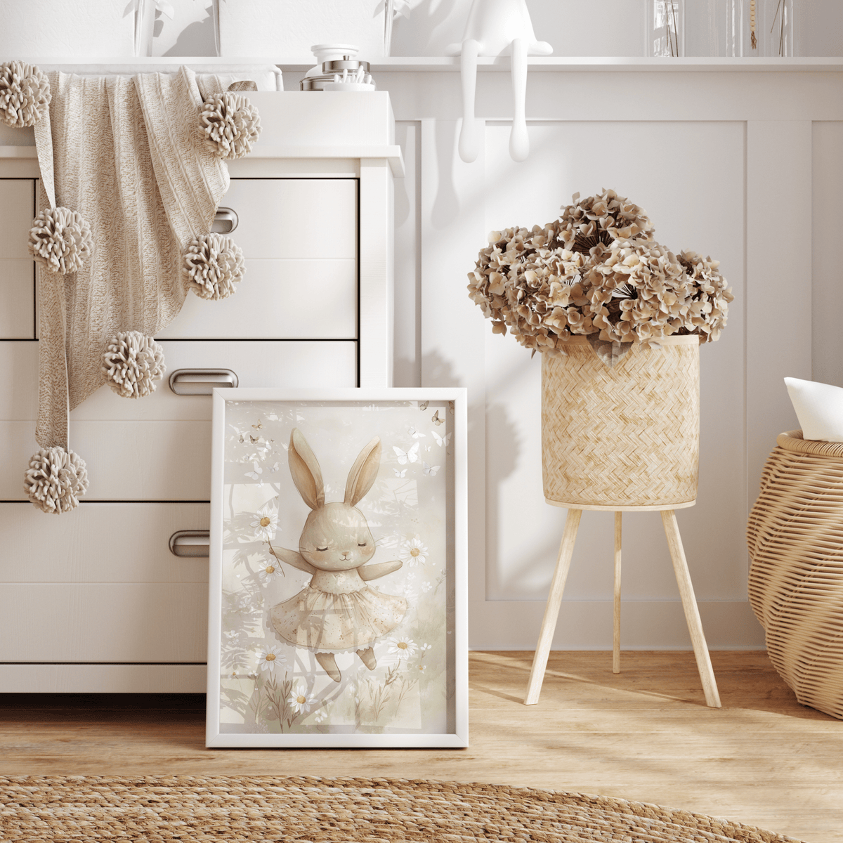 Neutral bunny print in a natural frame leaning beside a white nursery dresser with dried hydrangeas
