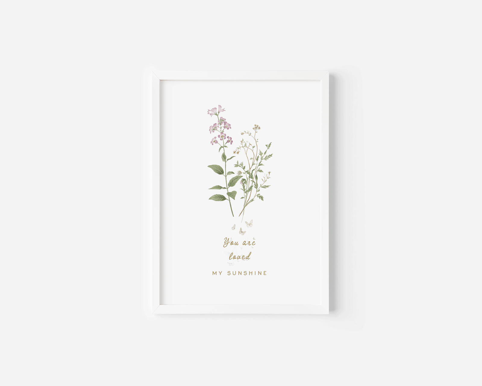 Neutral floral wall art in a white frame featuring soft pastel botanicals, styled in a bright minimalist nursery setting.