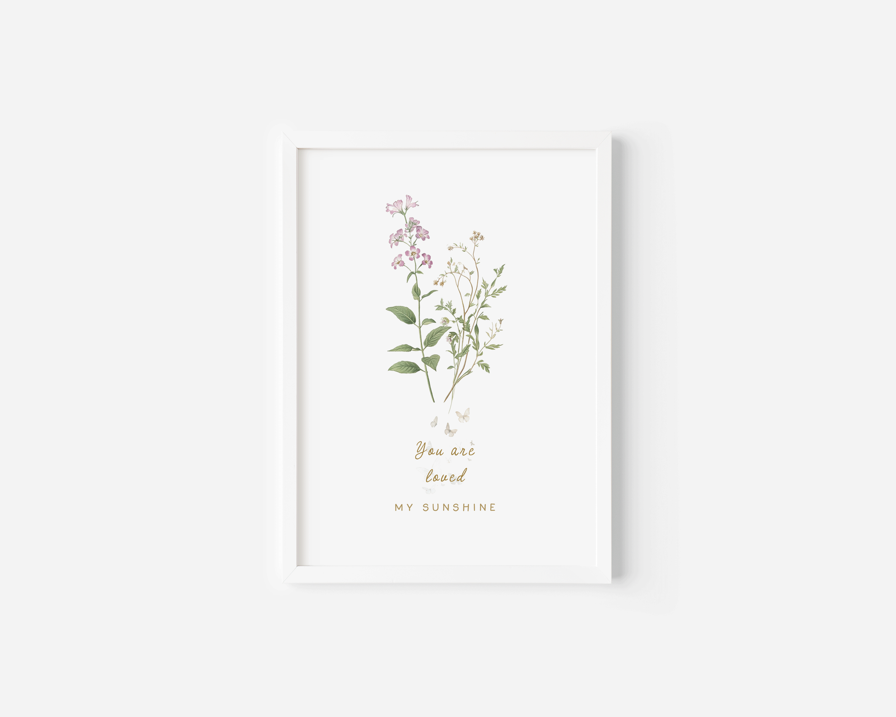 Neutral floral wall art in a white frame featuring soft pastel botanicals, styled in a bright minimalist nursery setting.