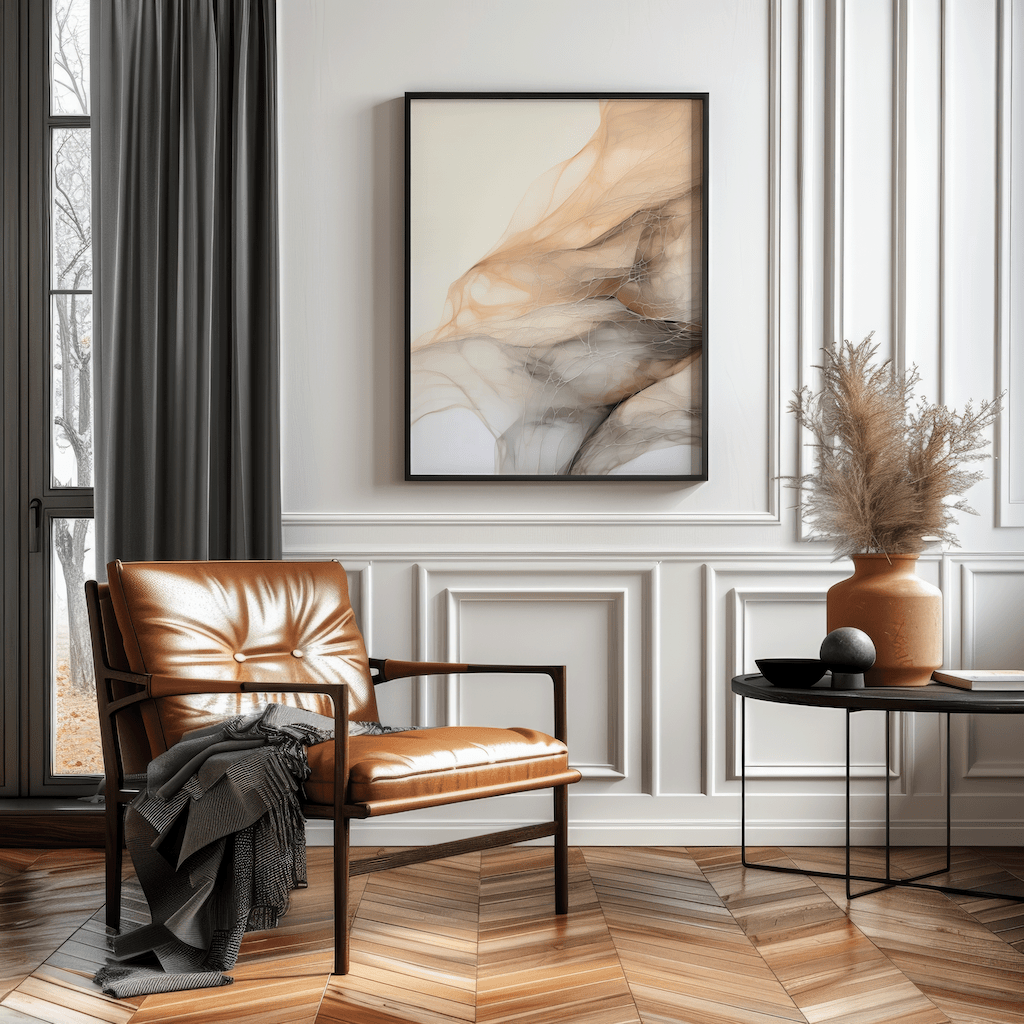 Beige abstract canvas wall art framed in black above caramel leather accent chair in living room