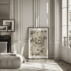 Neutral minimal creamy beige and vintage green floral wall art framed leaning against wall near window in bright natural light living room