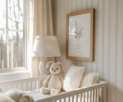 Neutral nursery wall art above a crib, with soft botanical florals in a natural wood frame