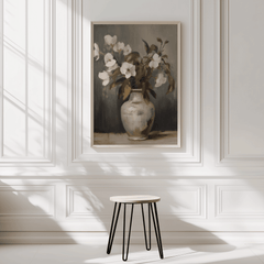 Neutral vintage floral wall art framed on minimal white wall with soft natural light and a stool
