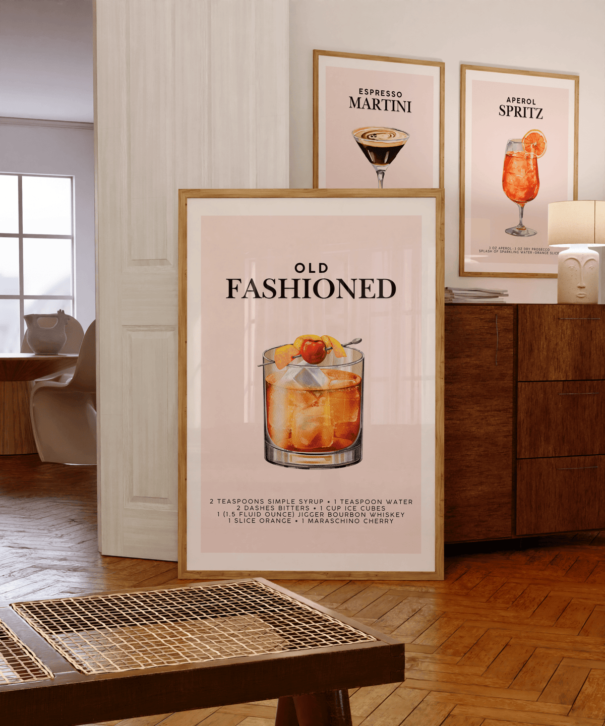 Old Fashioned print in a bar cart gallery wall beside espresso martini and Aperol spritz prints on a wooden sideboard